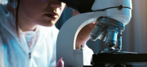 Researcher using a microscope to look at a slide