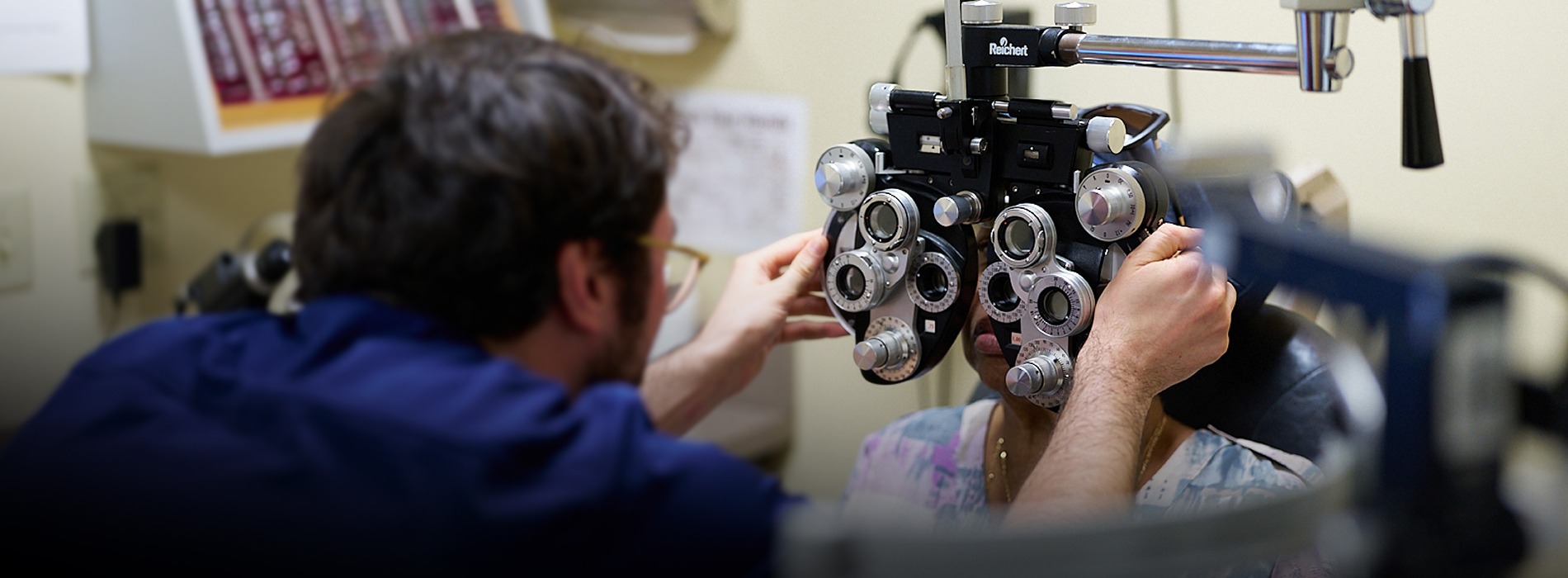 NECO student examining an elderly female patient at NECO Center for Eye Care - Roslindale