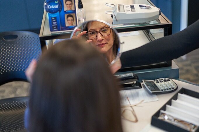 Patient trying on eyeglass frames at NECO Center for Eye Care - Roslindale